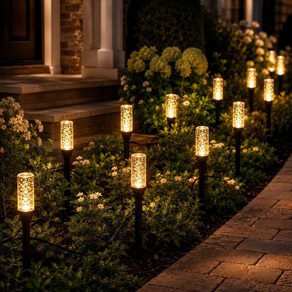 Warm LED solar pathway light option creating a golden glow beside a walkway